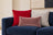 Red and ash gray corduroy pillows with a blush velvet lumbar on a navy sofa